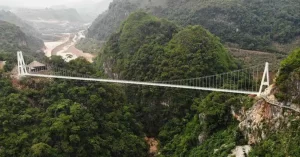 El acceso a este puente colgante es mediante una pasarela (también transparente) que serpentea la pared de una montaña emulando el cuerpo, precisamente, de un dragón.