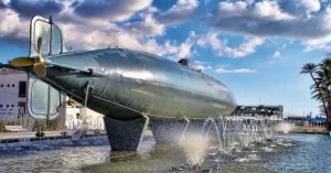 El submarino Peral expuesto en una explanada frente al antiguo Cuartel de Guardiamarinas y de las escaleras de la Muralla de Cartagena (Murcia).