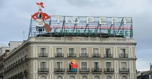 El famoso luminoso del 'Tio Pepe' en la Puerta del Sol cuenta entre sus proezas más importantes la de haber resistido a los bombardeos de la Guerra Civil. En la imagen en su situación original, en el edificio del desaparecido hotel París