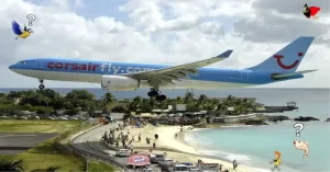 Un avión Airbus A330 de Corsairfly aterrizando en el Aeropuerto Internacional Princesa Juliana, al lado de la playa.