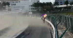 Turista practicando el arriesgado deporte de resistir las fortísimas ráfagas de aire que expiden las turbinas de los aviones que despegan del aeropuerto de la isla de San Martín.