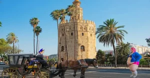 Fotografía: La Torre del Oro es una torre albarrana de época almohade. Levantada en la orilla izquierda del Guadalquivir, tenía como función vigilar el río e impedir la entrada de navíos, tensando una cadena que llegaba hasta un fortín en la ribera opuesta. Tras el descubrimiento de América, se utilizaba como depósito de los lingotes de oro (de ahí el nombre) traídos por los galeones de Indias.